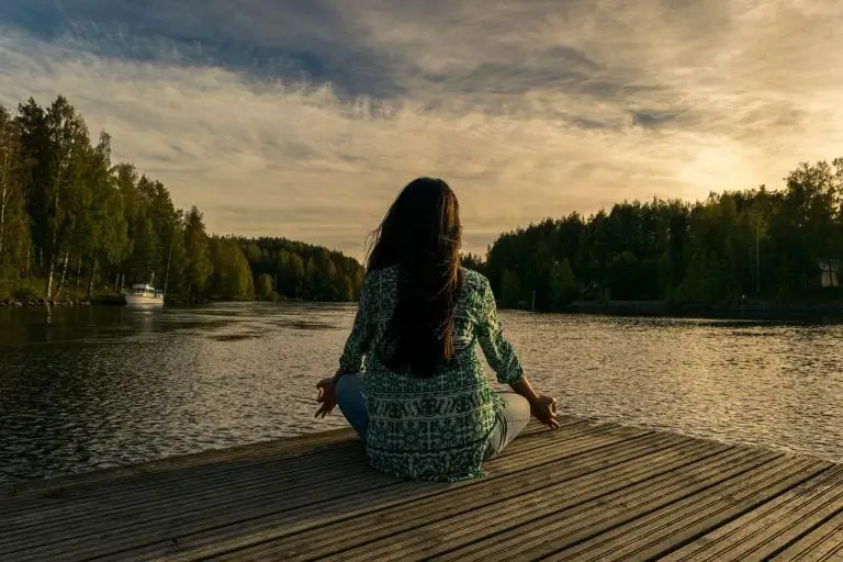 Vrouw mediteert bij de rivier in Enschede