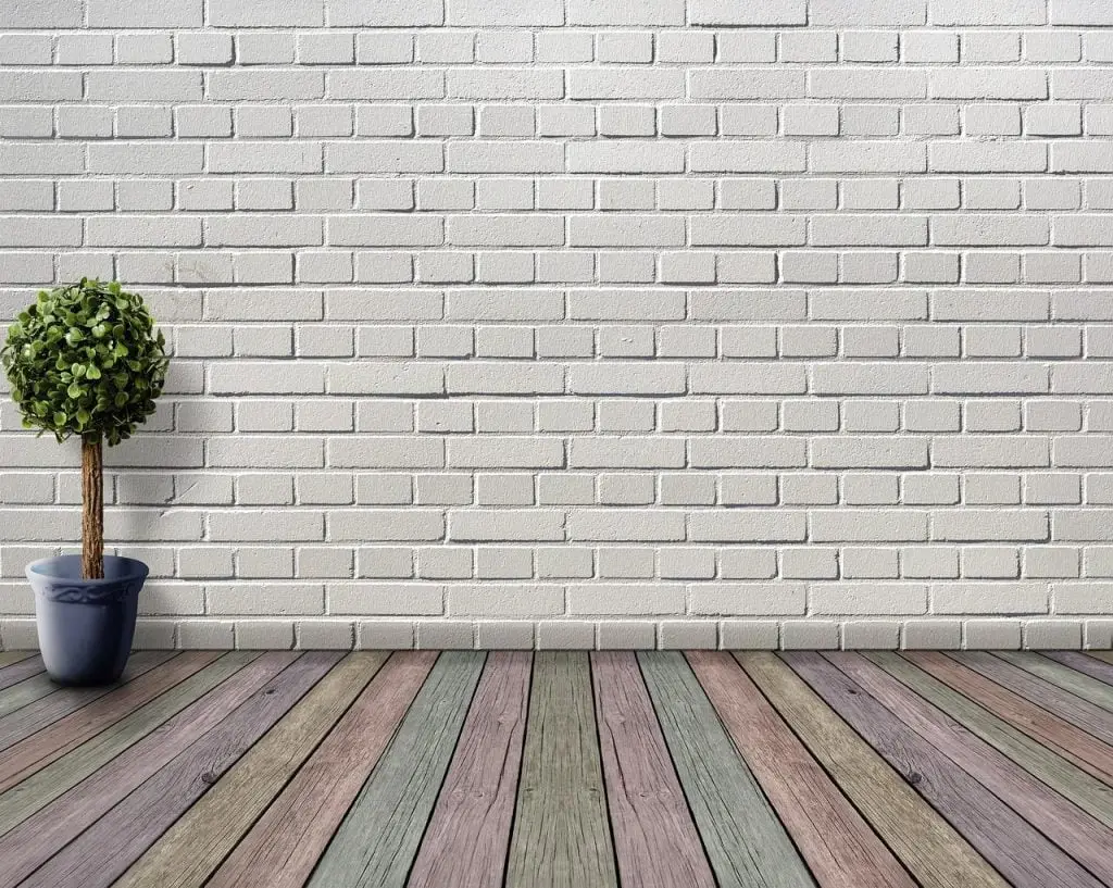 witte bakstenen muur kleurrijke houten vloer Met een bloempot aan de linkerkant van de kamer in Enschede