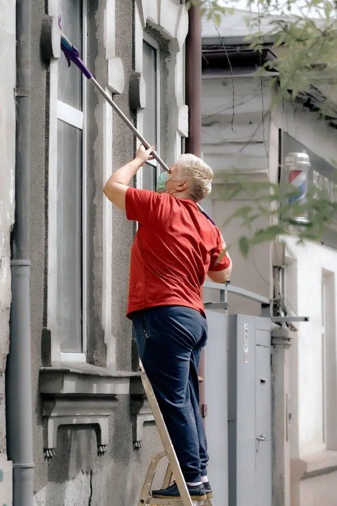 Een man maakt een spiegel schoon in Enschede