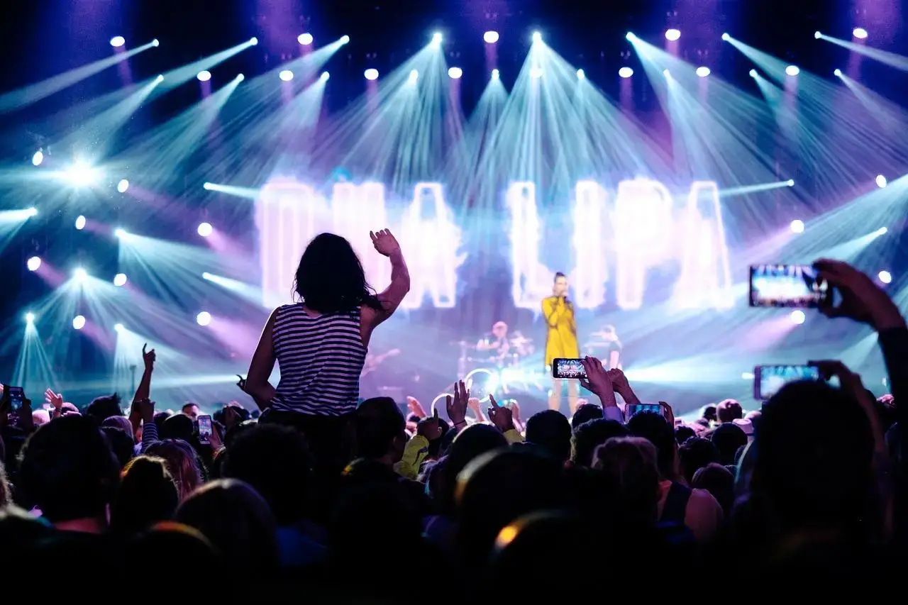 Een menigte mensen bij een concert met felle lichten in Enschede
