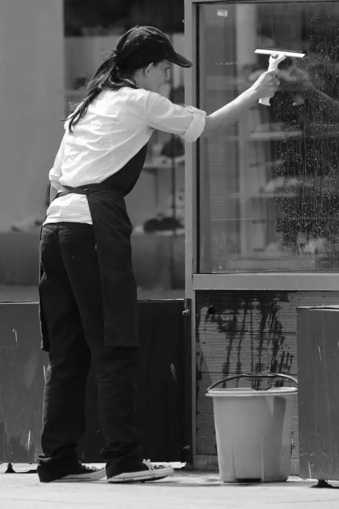 Een vrouw maakt een spiegel schoon in Enschede