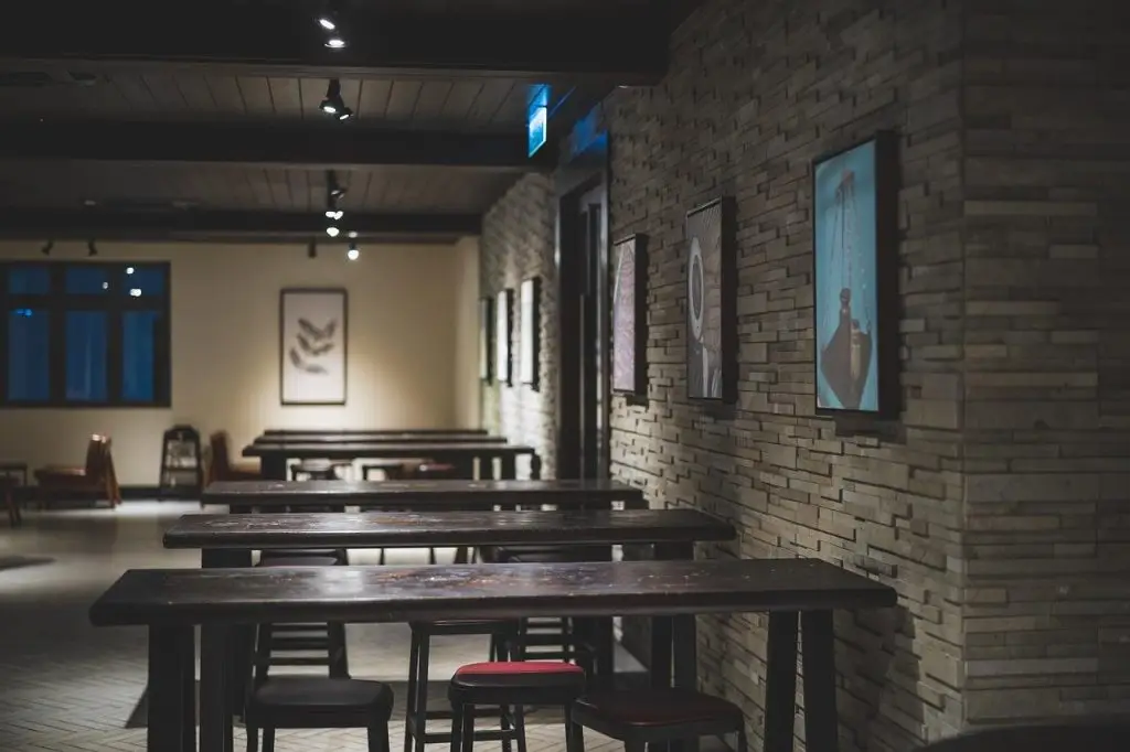 Een restaurant met tafels en stoelen voor een muur in Enschede