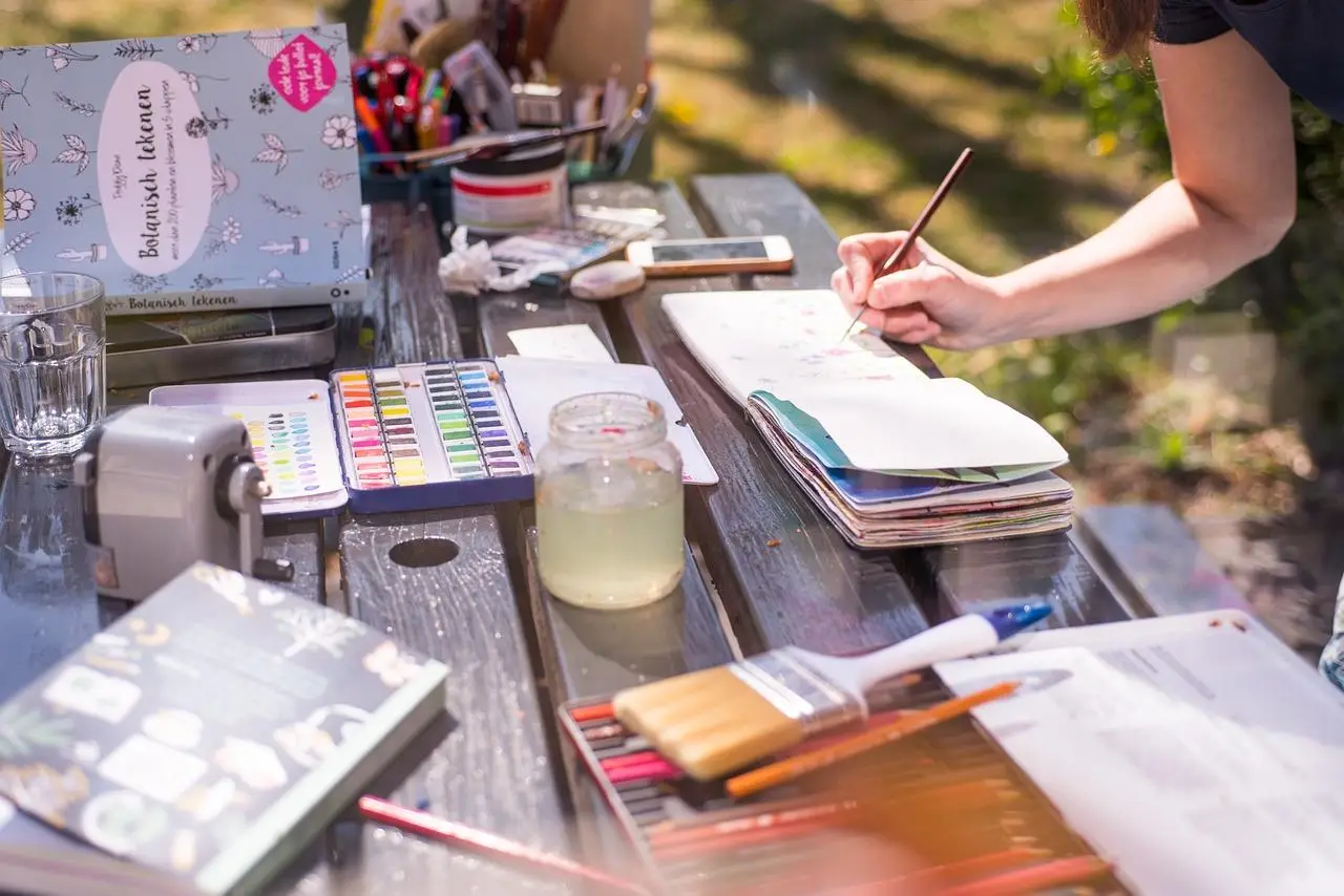 Een vrouw tekent op tafel met een penseel in Enschede